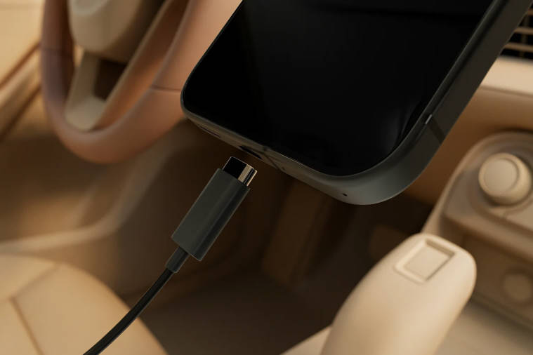 USBケーブルを使ってスマートフォンを車に接続し、Spotifyを再生しながら充電している様子